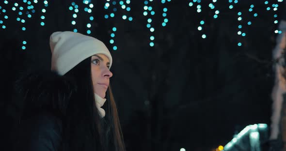 Woman Walks in the Evening Street in Winter