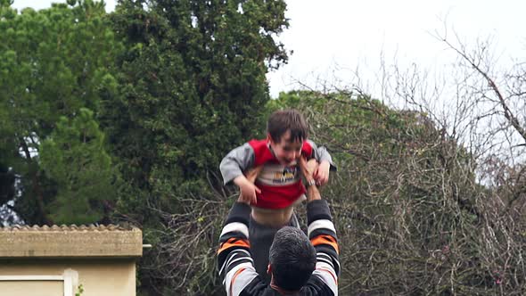 Slow motion of father throwing his adorable son in the air