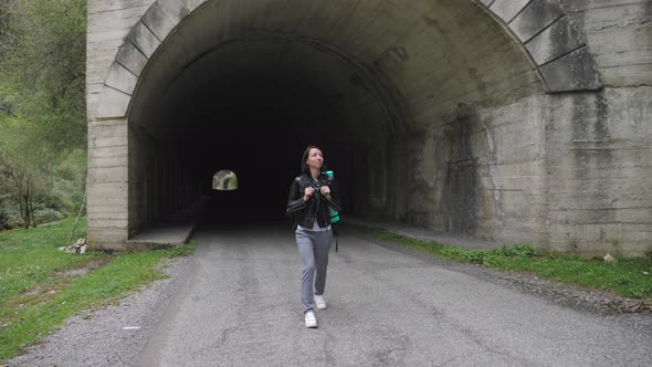 Traveler Woman with Backpack Walk Alone on Path Tunnel at the Road