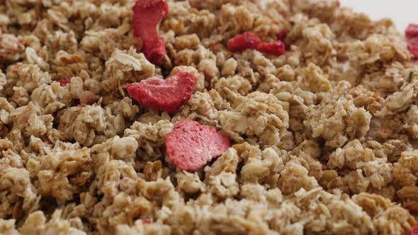 Tilting over muesli with strawberries on pile close-up 4K 2160p 30fps UltraHD footage - Dehydrated c