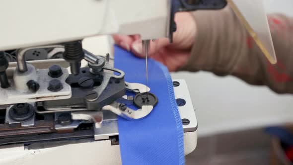 Female Worker Using Industrial Sewing Machine for Buttons