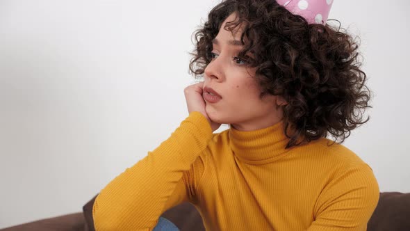 Upset Woman in Party Hat Looking Away Celebration Holiday Birthday Alone at Home