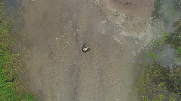 Aerial view of mature woman standing near a lake 4k