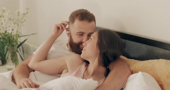 Romantic Couple Cuddling and Smiling While Lying on Bed Early Morning, Man and Woman in Love Having