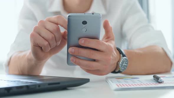 Businessman Using Smart Phone In Office