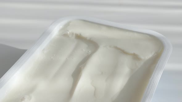 Cream cheese in plastic box 4K tilting footage