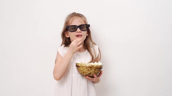 Girl with Glasses to Watch 3D Movies with Popcorn Stands Against White Wall