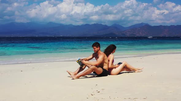 Guy and girl tanning on perfect island beach wildlife by blue lagoon with white sand background of G