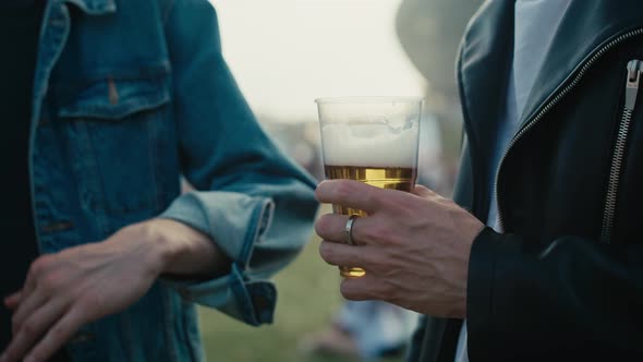 Close up of unrecognizable man holding a disposable cup with beer.  Shot with RED helium camera in 8