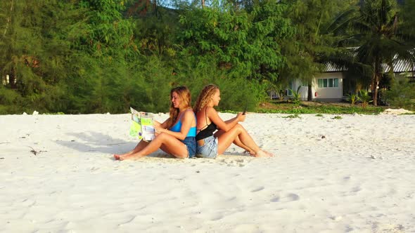 Ladies together happy together on relaxing shore beach adventure by shallow sea and white sandy back