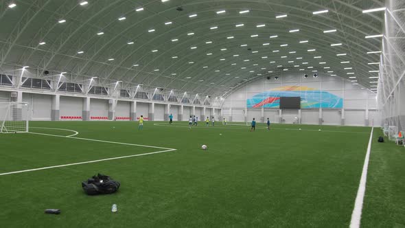 Children Play Football on Indoor Field at Sports Complex