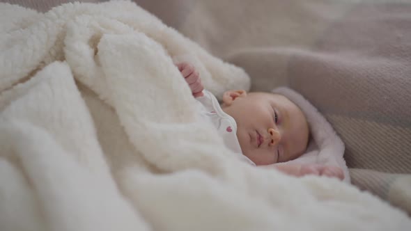 Zoom Out From Cute Caucasian Newborn Kid Lying in White Blanket Falling Asleep