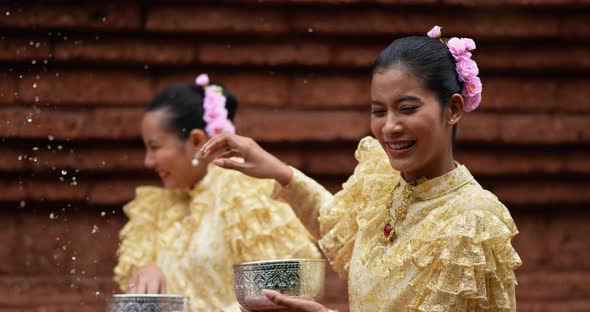 Young beautiful women enjoy to splashing water on Songkran festival