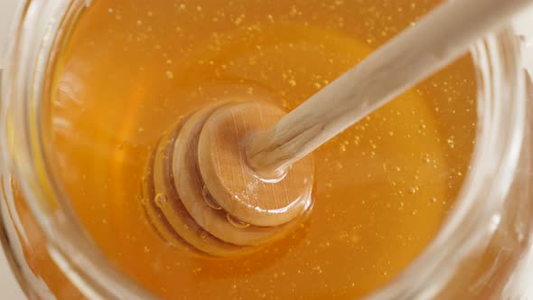 Golden sweet food substance and useful utensil 4K 2160p 30fps UltraHD footage - Wooden honey dipper 