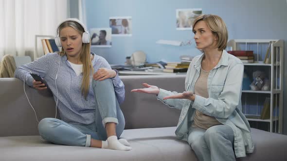 Girl in Music Headphones Showing Stop Gesture to Shouting Mother, Generation Gap