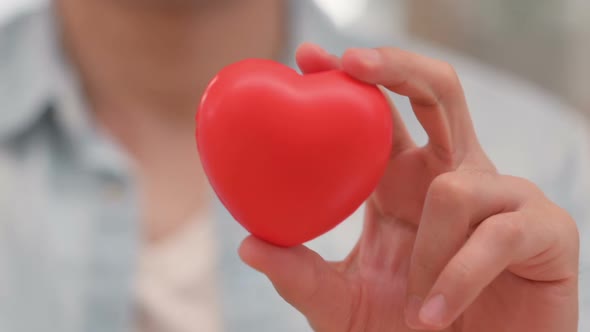 Close Up of Man Showing Red Heart