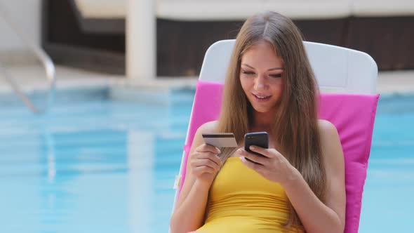 Happy Young Woman in Swimsuit Holding Credit Card Using Instant Mobile Payments