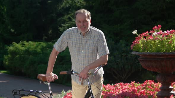 Handsome Mature Man on Bicycle at Park.