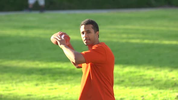 A father teaching his sons how to play American football.