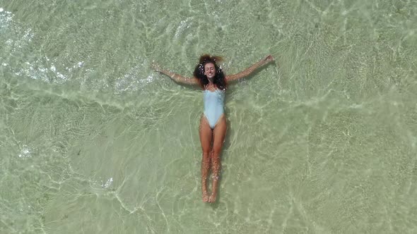 View From the Top As a Woman in White Swimsuit Swims in the Ocean