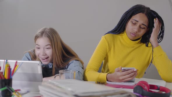 Beautiful Caucasian Girl Having Video Call on Tablet, Looking at Upset African American Friend