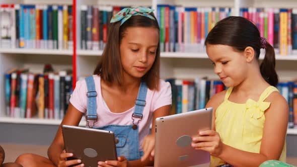 School kids using digital tablet in library