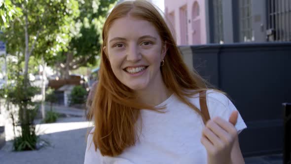 Portrait of a young woman smiling in the street