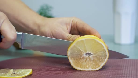 Man cutting yellow lemon with knife on chopping board white background with fruits. sliced lemon on