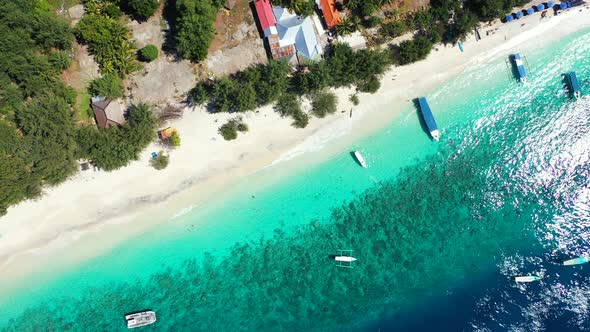 Daytime drone island view of a white paradise beach and aqua blue water background 