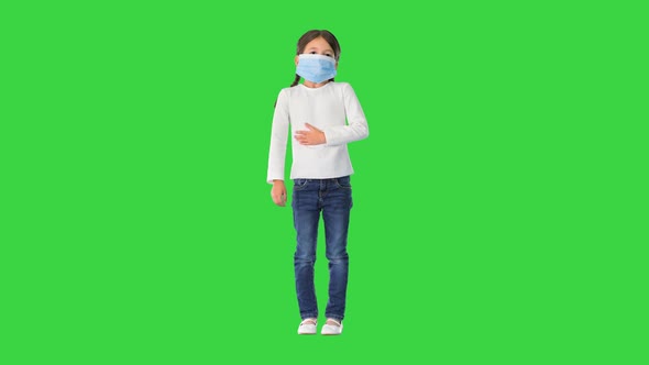 Little Girl Wearing Protective Face Mask Taking Deep Breaths Looking at Camera on a Green Screen