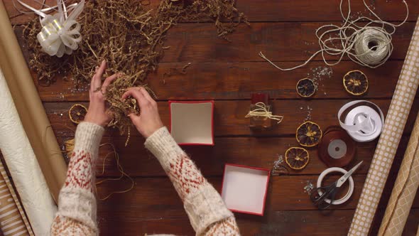 Hands of Woman Packing Perfume in Gift Box for Christmas