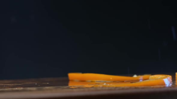 Slices of Yellow Bell Pepper Fall on Brown Wooden Board