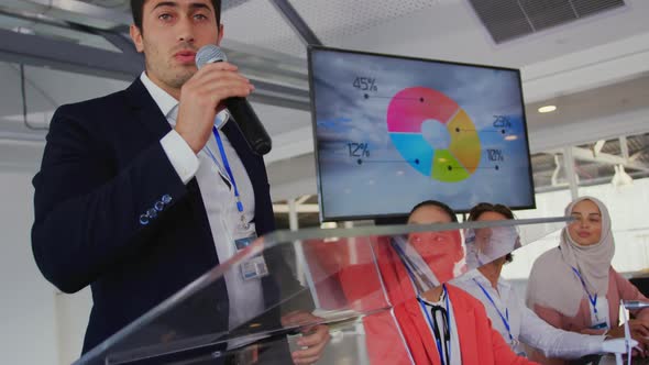 Male speaker addressing the audience at a business conference