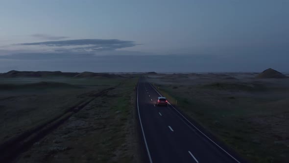 Aerial View of Ring Road in Iceland with Fast Driving Car at Sunset