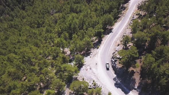 Aerial view over mountain road going through forest at National Park