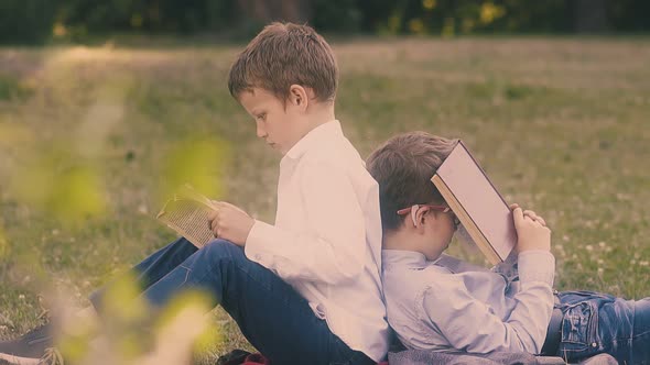 Exhausted Pupils Sit on Green Garden Lawn and Read Books