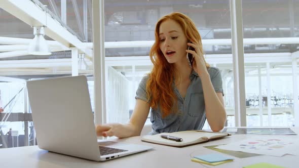 Executive talking on mobile phone while using laptop 4k