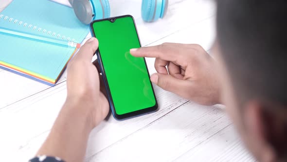 Rear View of Young Man Using Smart Phone Indoor