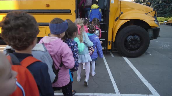 Lined Up Elementary Age Kids Boarding School Bus