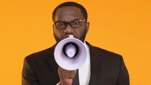 Angry African-American Boss in Suit Using Megaphone to Yelling on Employees