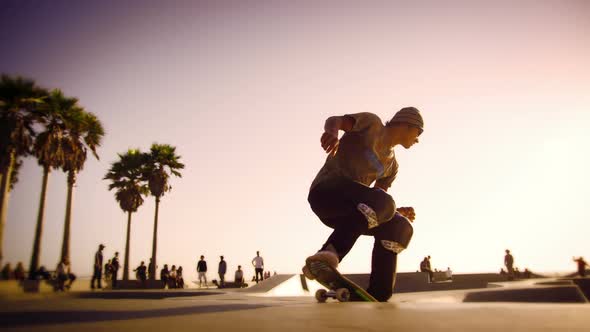 People enjoy sunset at Ocean Front Walk near Venice Beach California in slow motion with lens flare