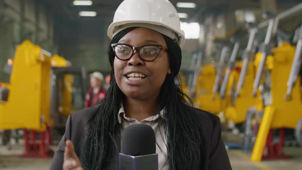 Female TV Journalist Telling about Heavy Machinery Factory on Camera