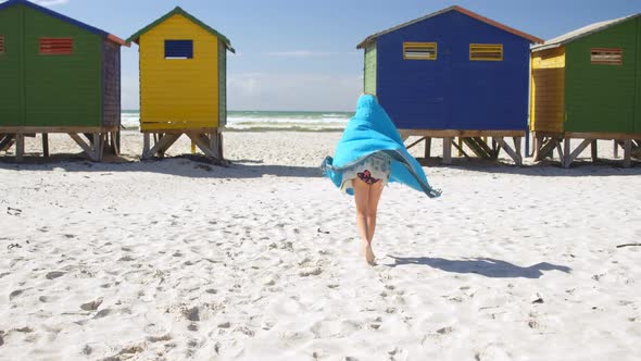 Girl with towel walking in the beach