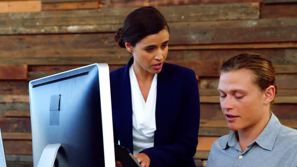 Business executives interacting with each other at desk