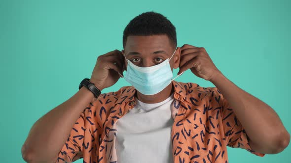 Portrait of Serious Male Putting Medical Face Mask