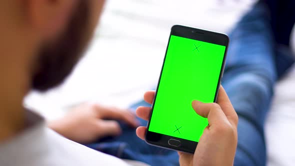 Black Smartphone with Green Screen for Chroma Key Compositing the Hands Swipe Up of a Man