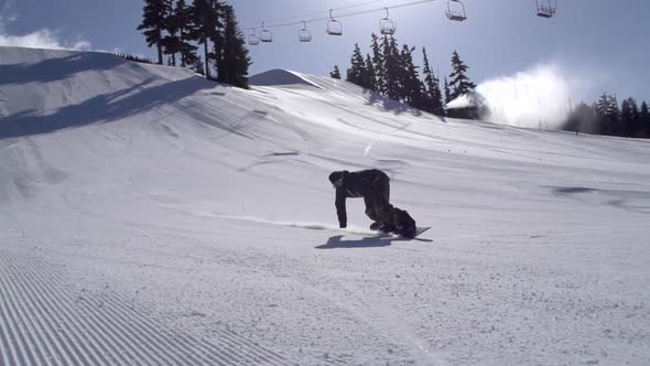 A young man snowboarding down a snow covered mountain.
