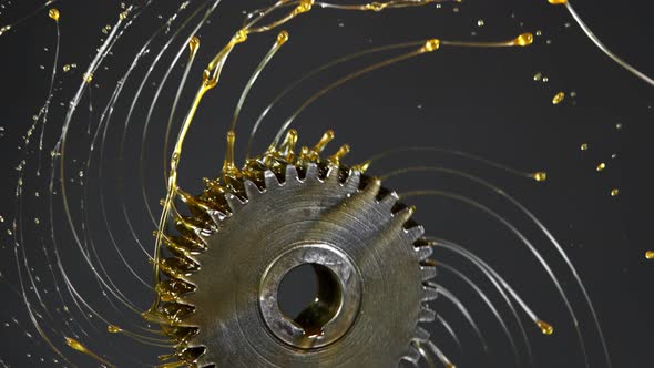 Super Slow Motion Shot of Rotating and Splashing Metal Cogwheel on Dark Background at 1000 Fps.