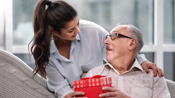 Daughter Granddaughter Giving Gift Box to Father Grandfather