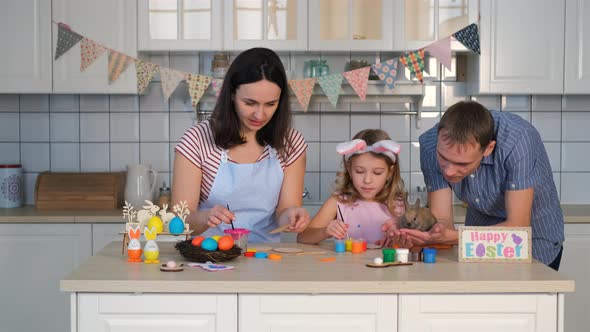 Family Preparing Easter Decorations in Kitchen